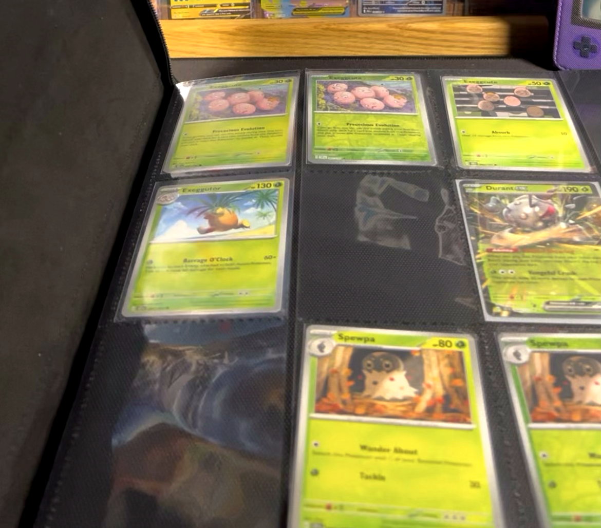 Our Surging Sparks master set binder in progress, cards sleeved with empty slots still to fill